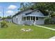 Charming gray home featuring a well-maintained front yard and a blue-covered porch at 1322 New York Ave, St Cloud, FL 34769