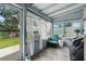 Cozy sunroom with ample windows, a comfortable green chair, and a view of the well-maintained backyard at 1322 New York Ave, St Cloud, FL 34769