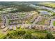 An aerial view of a community of tan homes with brown roofs, interspersed with trees and ponds at 1416 Oak Marsh St, Davenport, FL 33837