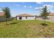 A spacious backyard with lush green grass, young trees, and partial fencing provides privacy and charm at 1416 Oak Marsh St, Davenport, FL 33837