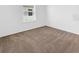 An empty bedroom is carpeted and has white walls and a window that lets in light at 1416 Oak Marsh St, Davenport, FL 33837