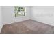 This empty bedroom is carpeted, has white walls, and a window that lets in light at 1416 Oak Marsh St, Davenport, FL 33837