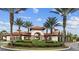 Community entrance featuring Mediterranean-style architecture, lush landscaping, and decorative palm trees at 1416 Oak Marsh St, Davenport, FL 33837