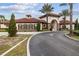 Community entrance featuring a grand archway, tile roof, and lush landscaping creating an inviting welcome at 1416 Oak Marsh St, Davenport, FL 33837