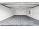 This is an empty garage with a white ceiling and walls, with a light in the middle and a gray floor at 1416 Oak Marsh St, Davenport, FL 33837