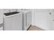 The laundry room features white appliances and tile flooring, with a white door leading to the other rooms at 1416 Oak Marsh St, Davenport, FL 33837
