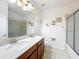 Bathroom featuring double sinks, wood cabinets, large mirror, and shower with glass door at 14234 Desert Haven St # 14234, Windermere, FL 34786