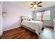 Comfortable bedroom featuring a ceiling fan, window with curtains, and wood flooring at 14234 Desert Haven St # 14234, Windermere, FL 34786