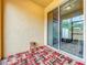 Enclosed patio with patterned carpet and a stool next to glass sliding door at 14234 Desert Haven St # 14234, Windermere, FL 34786