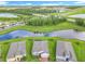 An aerial perspective features homes bordering a pond, mature trees, and manicured green lawns at 159 Olympus Way, Kissimmee, FL 34759