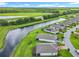 An aerial view features homes next to a canal, manicured lawns, and solar panels on rooftops at 159 Olympus Way, Kissimmee, FL 34759