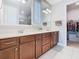Bathroom featuring double sinks, wood cabinetry, ample counter space and access to closet at 159 Olympus Way, Kissimmee, FL 34759