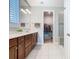 Bathroom with double vanity, wood cabinets, tile flooring and a walk-in closet view at 159 Olympus Way, Kissimmee, FL 34759