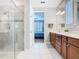 Bright bathroom featuring a glass shower, a double vanity and a view of the bedroom at 159 Olympus Way, Kissimmee, FL 34759