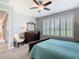 Bedroom featuring a ceiling fan, plantation shutters, and an adjacent bathroom at 159 Olympus Way, Kissimmee, FL 34759