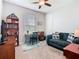 Bedroom featuring a dark blue sofa, ceiling fan, and a gray desk with a chair at 159 Olympus Way, Kissimmee, FL 34759