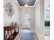 Inviting entryway with decorative light fixture, stylish console table, and elegant glass-paneled front door at 159 Olympus Way, Kissimmee, FL 34759