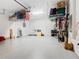 Spacious garage with overhead storage racks and clean epoxy flooring offers ample space for vehicles and storage at 159 Olympus Way, Kissimmee, FL 34759