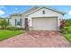 A well-maintained garage and brick driveway contribute to the home's curb appeal at 159 Olympus Way, Kissimmee, FL 34759