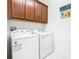 Clean laundry room equipped with a washer and dryer and plenty of storage space at 159 Olympus Way, Kissimmee, FL 34759