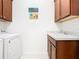 Bright laundry room with a washer, dryer, and a convenient utility sink at 159 Olympus Way, Kissimmee, FL 34759