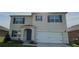 Charming two-story home with a two-car garage, beautiful facade, and well-maintained front yard at 1591 Barberry Dr, Kissimmee, FL 34744
