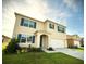 Two story home with blue shutters, well-manicured lawn, and attached two car garage at 1591 Barberry Dr, Kissimmee, FL 34744