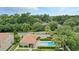 Aerial view of the community pool with mature trees, lounge chairs, and landscaping at 196 Canterbury Bell Dr, Oviedo, FL 32765