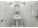 Well-lit powder room features a pedestal sink, decorative mirror, and towel rack at 196 Canterbury Bell Dr, Oviedo, FL 32765