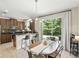 Bright kitchen with stainless steel appliances, dark wood cabinets, and a granite-topped breakfast bar overlooking the dining area at 196 Canterbury Bell Dr, Oviedo, FL 32765