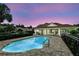 Community pool featuring a pool house with a red tile roof, surrounded by brick pavers and black fencing at 196 Canterbury Bell Dr, Oviedo, FL 32765