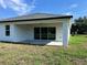 Exterior view of the home featuring the back patio, sliding glass doors, and backyard space at 202 Bromwich Dr, Kissimmee, FL 34758