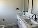 Bathroom featuring a double vanity with modern black fixtures, and a clean, minimalist design at 202 Bromwich Dr, Kissimmee, FL 34758