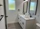 Modern bathroom featuring double vanity, sleek mirrors, and modern black fixtures, plus a window at 202 Bromwich Dr, Kissimmee, FL 34758