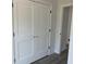 Hallway featuring crisp white trim, wood-look floors, and paneled doors leading to another room at 202 Bromwich Dr, Kissimmee, FL 34758