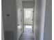 Narrow hallway featuring white walls, contrasting doors, and a view into another room at 202 Bromwich Dr, Kissimmee, FL 34758