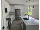 Modern kitchen with white cabinets, stainless steel appliances, black hardware, and a marble countertop island at 202 Bromwich Dr, Kissimmee, FL 34758
