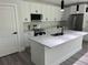 Stylish kitchen features white cabinetry, stainless steel appliances, marble countertops, and a kitchen island at 202 Bromwich Dr, Kissimmee, FL 34758