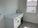 Bright laundry room with white cabinets, sleek black fixtures, and white marble patterned counter, perfect for everyday tasks at 202 Bromwich Dr, Kissimmee, FL 34758