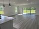 Open-concept living room with wood-look flooring, recessed lighting, large windows, and access to the outside at 202 Bromwich Dr, Kissimmee, FL 34758