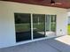 Covered back patio featuring a stained wood ceiling, fan, and sliding glass door into the home at 202 Bromwich Dr, Kissimmee, FL 34758