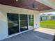 Covered patio area, featuring stained wood ceiling, fan, and access to a well manicured back yard at 202 Bromwich Dr, Kissimmee, FL 34758