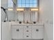 Bathroom featuring dual sinks, modern fixtures, and an oversized frameless glass shower with natural light at 2525 Ridgeway Dr, Kissimmee, FL 34746