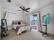 Bright bedroom with light carpet, a ceiling fan and sliding glass doors leading to the patio at 2525 Ridgeway Dr, Kissimmee, FL 34746
