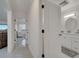 Bright hallway leading to a bathroom, featuring white tile and a peek into living area at 2525 Ridgeway Dr, Kissimmee, FL 34746