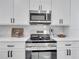 A bright kitchen featuring stainless steel appliances, white cabinetry, and modern fixtures at 2525 Ridgeway Dr, Kissimmee, FL 34746