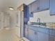 Kitchen featuring granite countertops, stainless steel refrigerator, and blue cabinets at 2525 Ridgeway Dr, Kissimmee, FL 34746