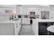 Well-lit kitchen showcasing white cabinetry, stainless steel appliances, and a stylish gray backsplash at 2525 Ridgeway Dr, Kissimmee, FL 34746