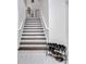Well-lit staircase with wooden steps and white railings; shoe rack at 2525 Ridgeway Dr, Kissimmee, FL 34746