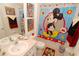 Whimsical bathroom with cartoon-themed shower curtain, colorful decor, and single sink vanity at 2585 Maneshaw Ln, Kissimmee, FL 34747
